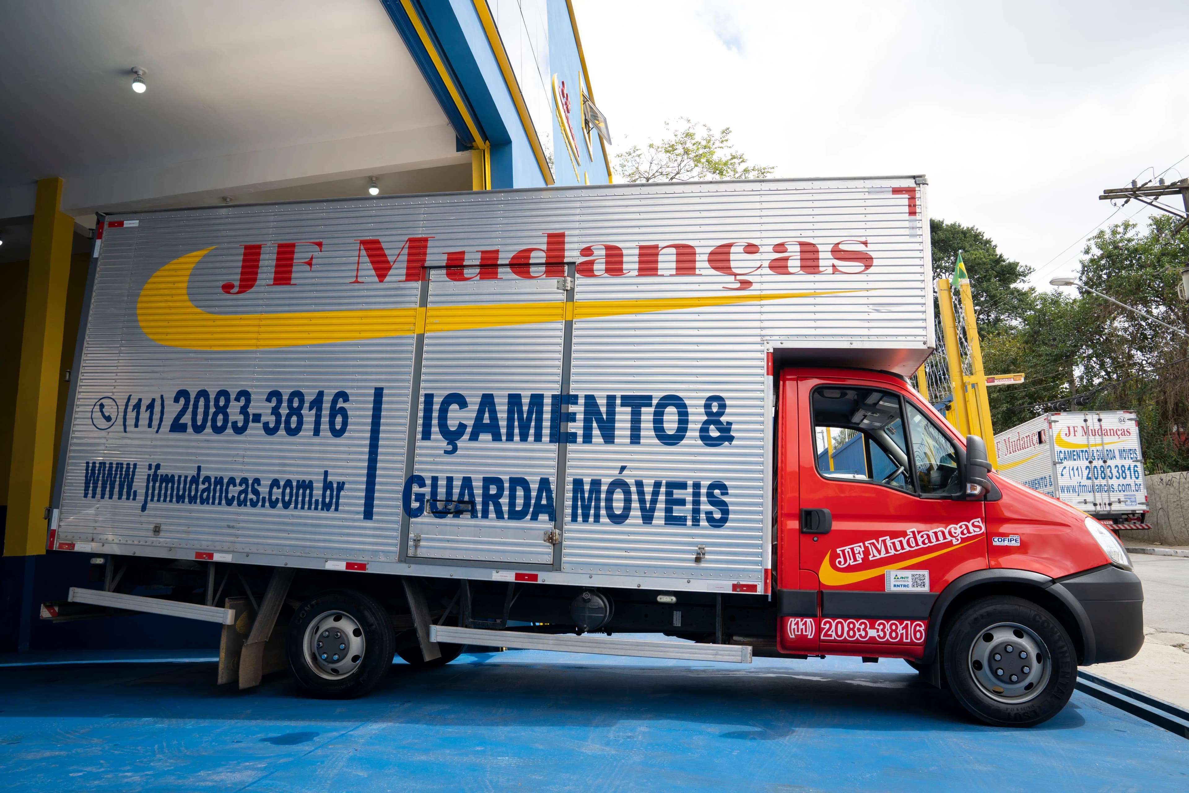 Caminhões de mudança JF Mudanças saindo da garagem