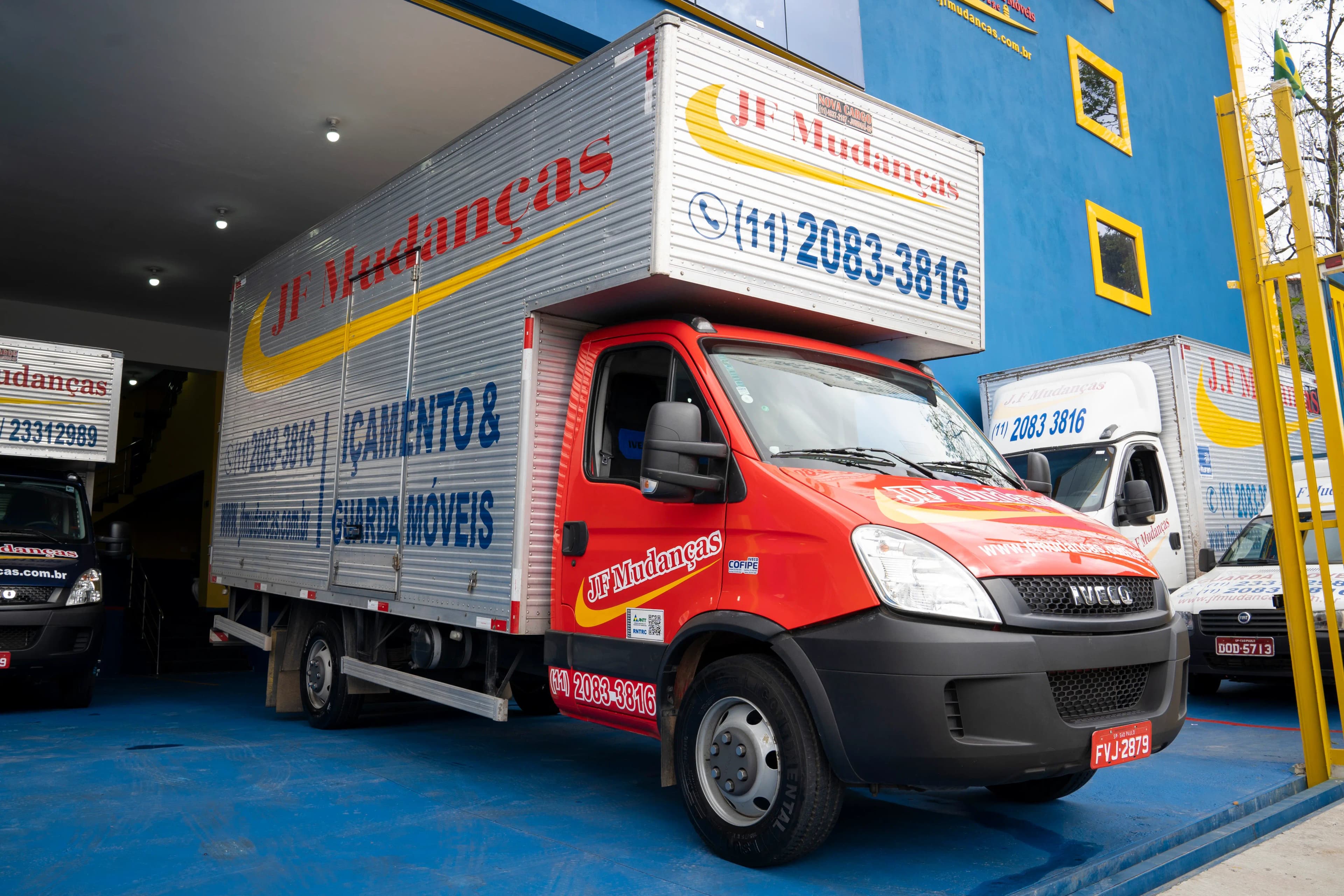 Caminhões de mudança JF Mudanças saindo da garagem