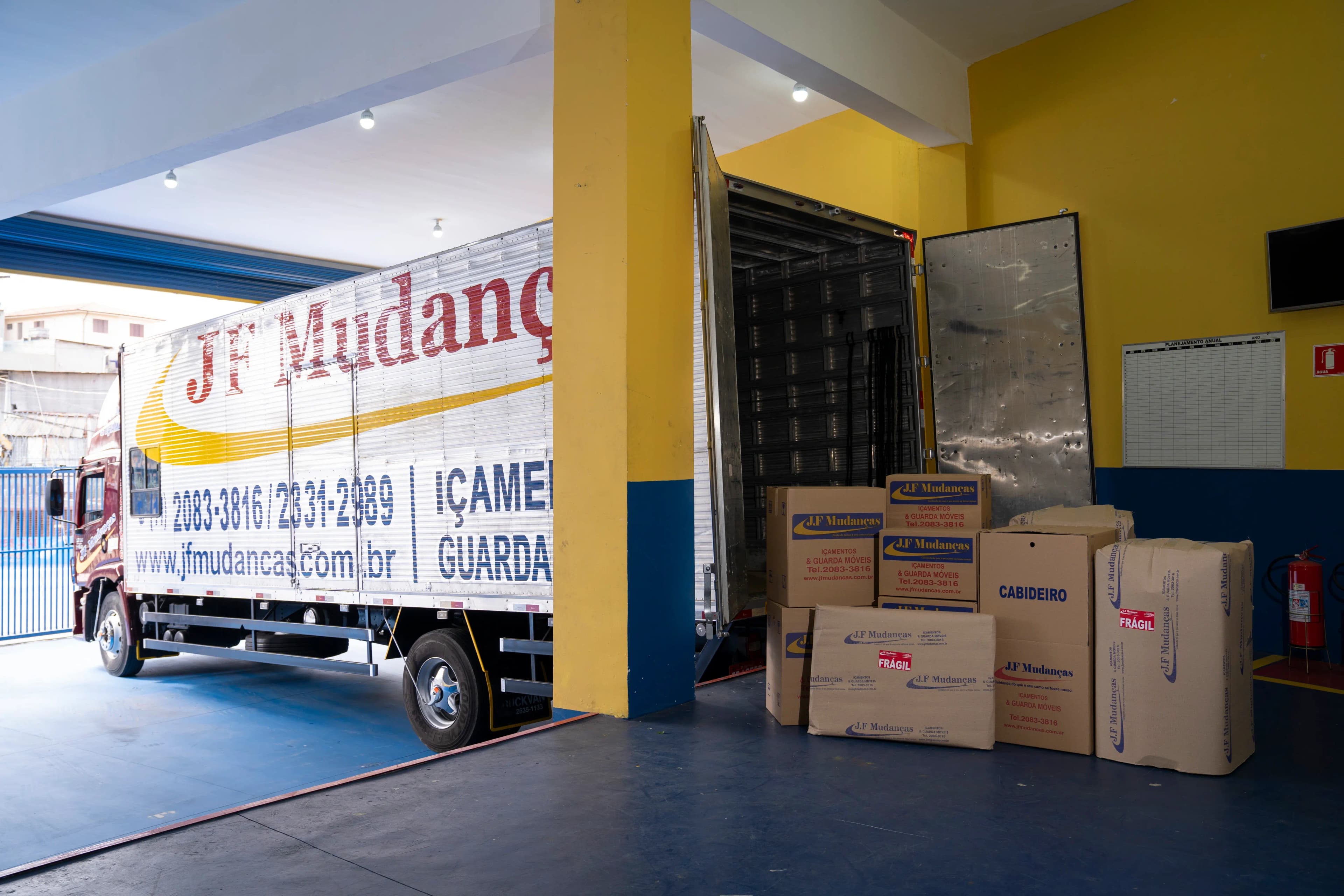 Caminhão JF Mudanças durante o descarregando de cargas na garagem da nossa unidade