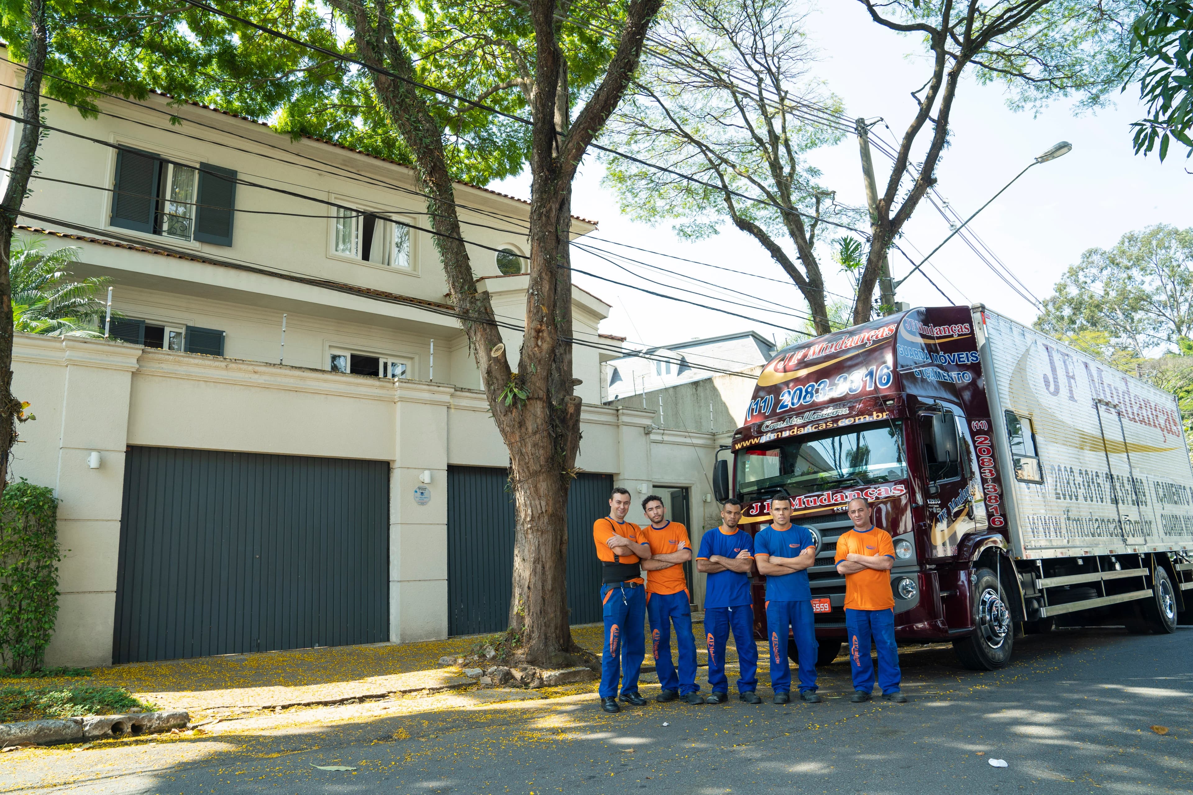 Equipe em frente do caminhão de mudança JF Mudanças
