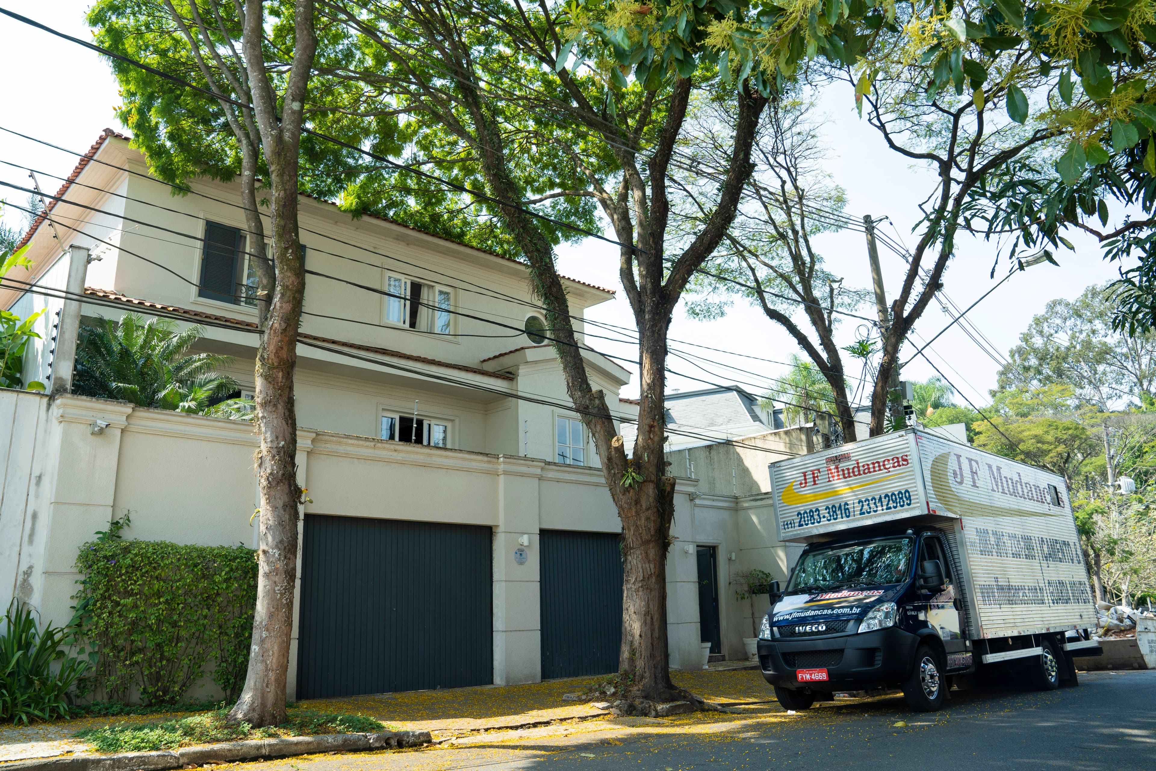 Caminhão de mudança JF Mudanças em frente a uma residência